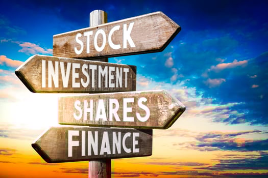 Stock, investment, Shares, Finance - Wooden Signpost with Four Arrows, Sunset Sky in Background photo