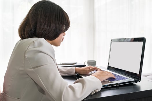 Young woman in smart casual wear working on laptop photo
