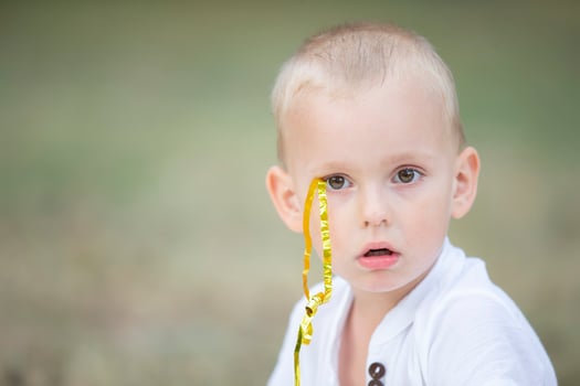 The face of a little surprised boy with a confetti ribbon. photo
