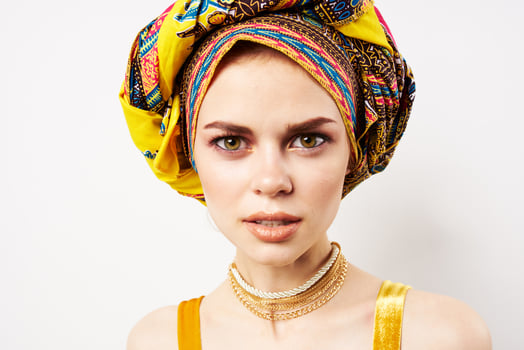 cheerful pretty woman in multicolored turban african style and fashion posing photo