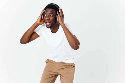 emotional man of african appearance in headphones listening to music light background photo