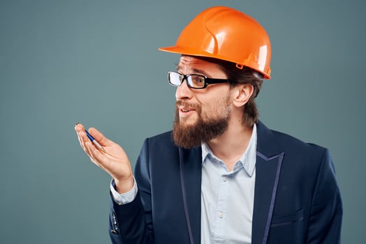 A man wearing an orange hard hat industry official job photo