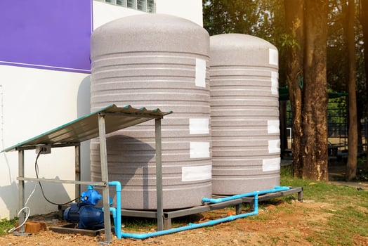 water tank and water pump installed outside the building. For use as a reserve of water for use in homes and offices. Made of special grade material, extra thick, UV protection and not moss. photo