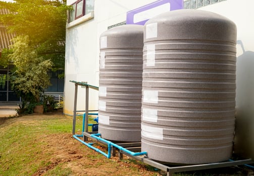 water tank and water pump installed outside the building. For use as a reserve of water for use in homes and offices. Made of special grade material, extra thick, UV protection and not moss. photo