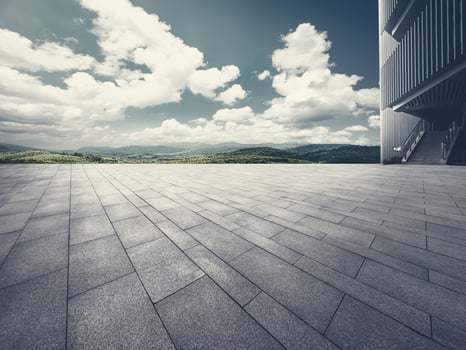 The empty brick square and building part with blue sky and mountain background. photo