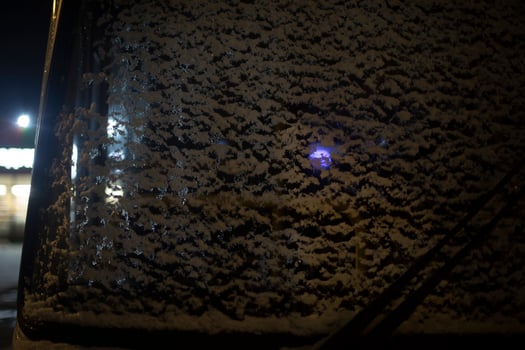 Snow on glass of bus. Transport at night in parking lot in detail. Front window of bus on winter day. photo