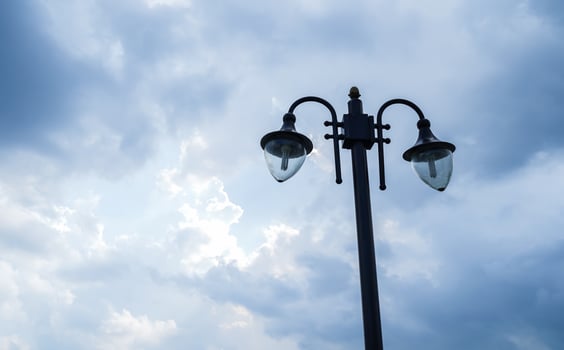 vintage street lamp, with two lamps, against a cloudy blue sky background photo