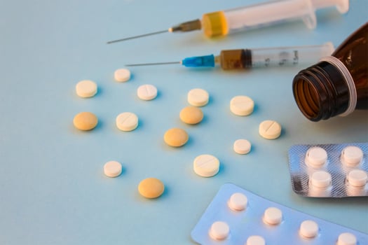 Pills, syringes on blue background. photo