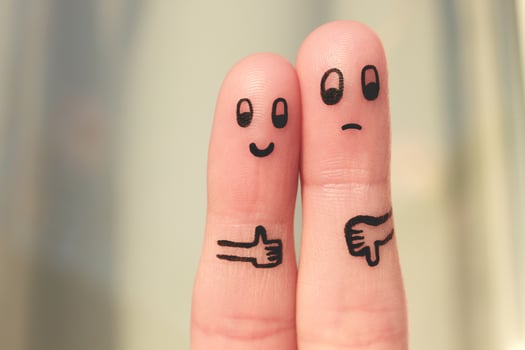 Finger art of couple. Woman showing thumbs up and man showing thumbs down. Concept of disagreement in family. photo