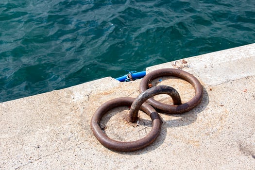 Mooring bollards on the quay of the sea.  Rusty mooring bollard on the dock of the sea photo
