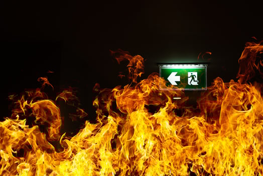 Green fire escape sign hang on the ceiling in the Warehouse. The concept of fire escape training and preparation for evacuation photo