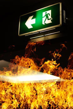Green fire escape sign hang on the ceiling in the Warehouse. The concept of fire escape training and preparation for evacuation photo