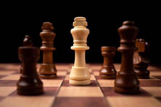 White king standing confront of Brown king and being in the chess circle. New business players are facing challenges. The management or leadership, analysis, strategy concept. photo