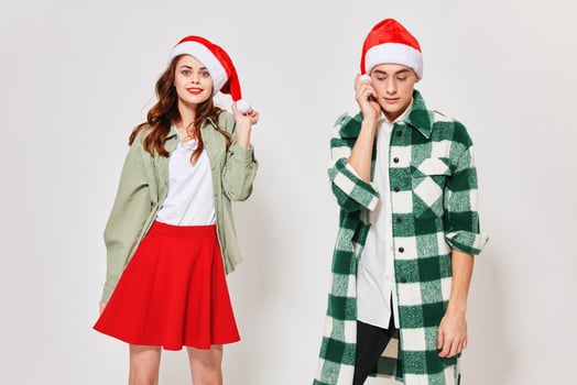 Happy young people on a light background in Christmas hats cropped view photo