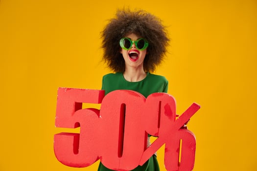 Portrait of a charming lady curly hairstyles green dress fifty percent discount yellow background unaltered photo