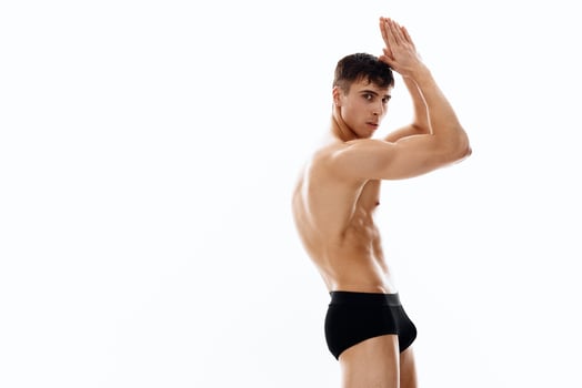young brunette man in panties and naked torso holds hands near face cropped view photo