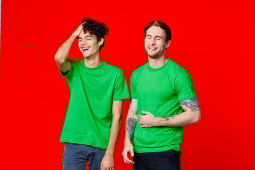 two friends in green t-shirts hold their belly emotions photo