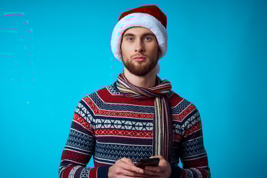 Cheerful man with a phone in hand holiday christmas technology blue background photo