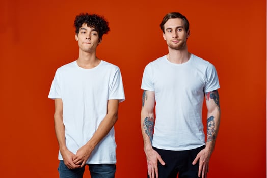 Two cheerful friends in white T-shirts are standing next to team emotions photo