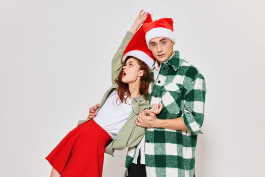 Cheerful drunk woman in the arms of a man Christmas holiday studio photo