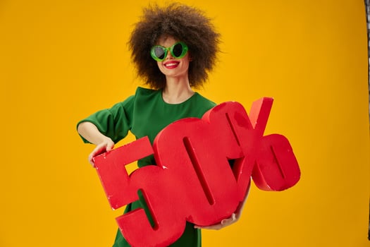 Beautiful fashionable girl curly hairstyles green dress fifty percent discount yellow background unaltered photo