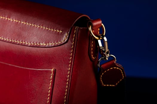 Part of a leather bag on a dark background. photo