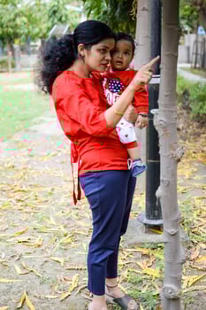 Loving mom carrying of her baby at society park. Bright portrait of happy mum holding child in her hands. Mother hugging her little 9 months old son. photo
