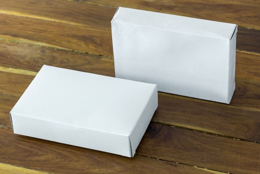 blank white cardboard package box mockup on dark wooden table photo