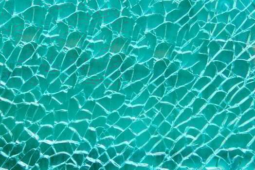 Broken glass texture with crack on blue background photo