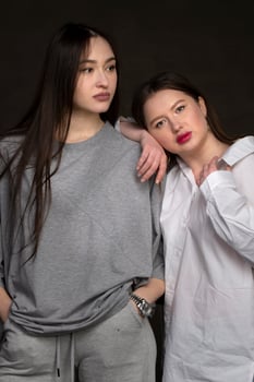 Two beautiful girls-friends on a dark background. photo