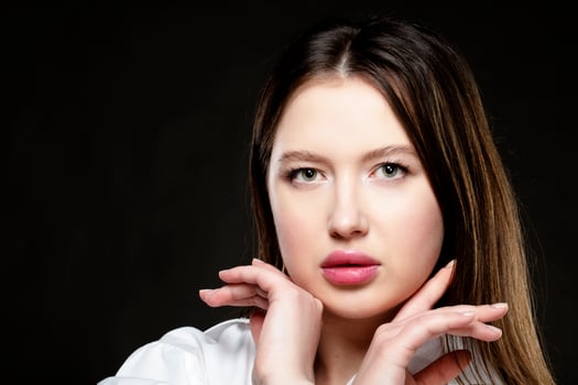 Beautiful girl model with pink sensual lips on a black background. photo
