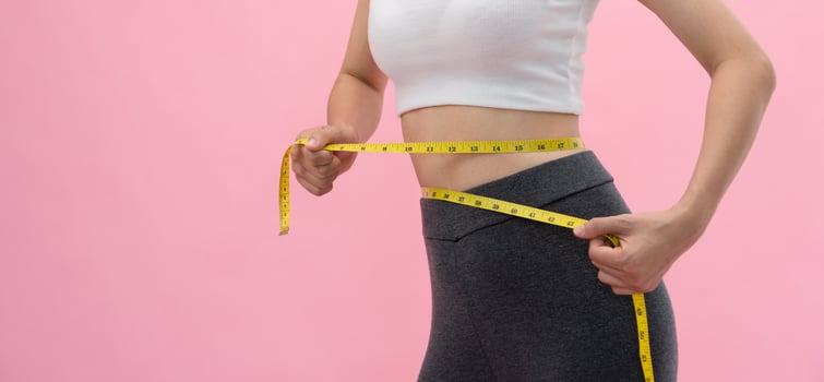 Diet and dieting. Beauty slim female body use tape measure. Woman in exercise clothes achieves weight loss goal for healthy life, crazy about thinness, thin waist, nutritionist. photo