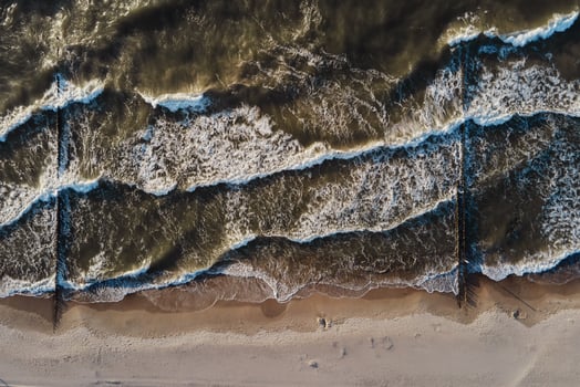 Coastline with sea waves and sand beach, top view photo