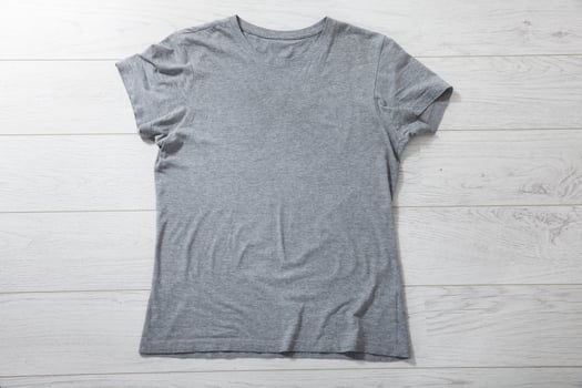 Shirt mockup - pleated, wrinkled t-shirt on white wooden desk top view photo