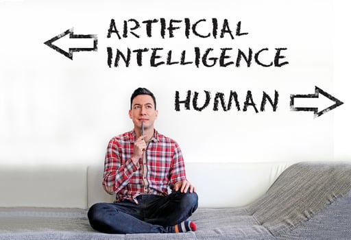 Man sitting on the couch with the words Artificial Intelligence and Human written on the wall next to him photo
