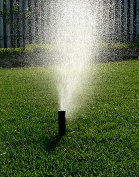 Automatic garden irrigation system watering lawn. Savings of water from sprinkler irrigation system with adjustable head. Automatic equipment for irrigation and maintenance of lawns, gardening. photo