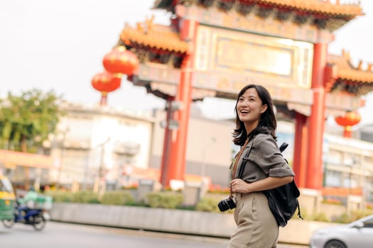 Young Asian woman backpack traveler enjoying China town street food market in Bangkok, Thailand. Traveler checking out side streets. photo