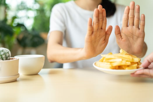 Beauty slim female body confuse french fries. Woman in restaurant achieves weight loss goal for healthy life, crazy about thinness, thin waist, nutritionist. Diet, body shape. photo