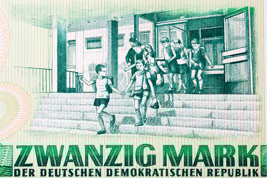 Several young children exiting a school from East German money photo