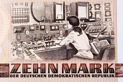 Female engineer sitting at a control console inside the Rheinsberg Nuclear Power Plant from East German money photo