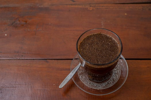 Close up photo a cup of arabica coffee with spoon from high angle. The photo is suitable to use for coffee shop background, menu poster and coffee content media.