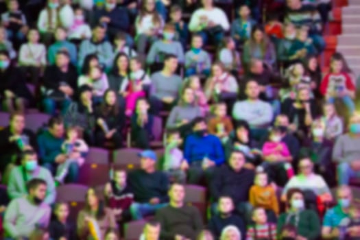 A blurred crowd of spectators in a stadium at a sporting event photo