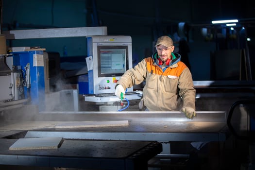 A furniture production worker behind a programmed machine makes furniture parts. Furniture manufacturing. photo