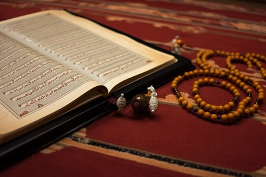 Muslim prayer and recitation elements illustration. Religious education and recitation concept. Islamic holy book of the Quran opened on a rug with prayer beads. . photo