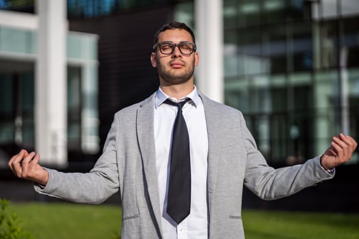 Businessman taking a break and meditating outside of the company building photo