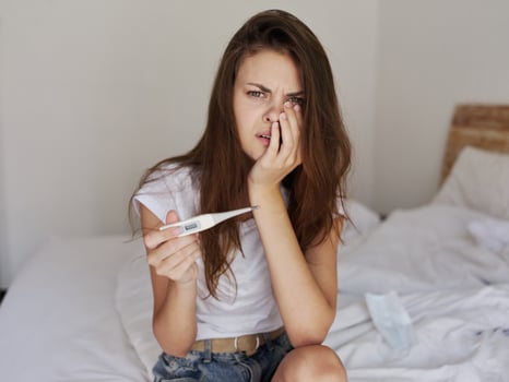 frustrated woman from thermometer in hands high temperature photo