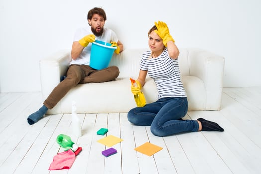 Woman washes the floors A man sits on the couch at home interior cleaning photo