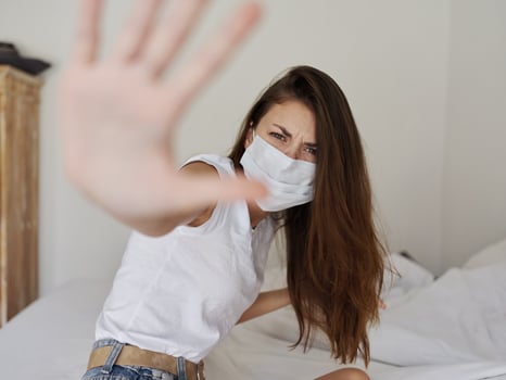 woman wearing medical mask irritability quarantine coronavirus pandemic covering face with palm photo