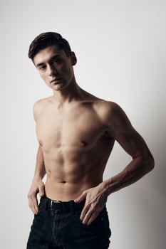 Muscular guy in pants nude torso cropped view over gray background photo
