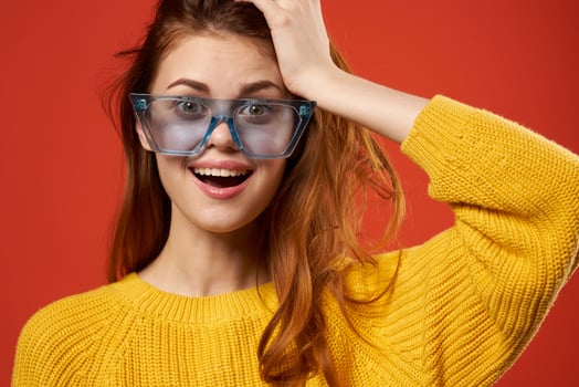 cheerful woman in yellow sweater blue glasses posing studio photo